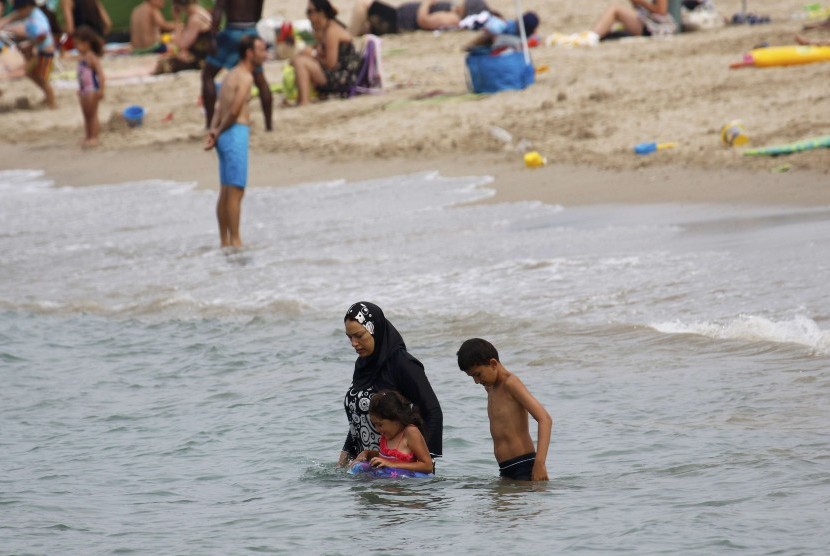 Wanita mengenakan baju renang Muslim yang tertutup penuh atau burkini di Pantai Marseilles, Prancis.