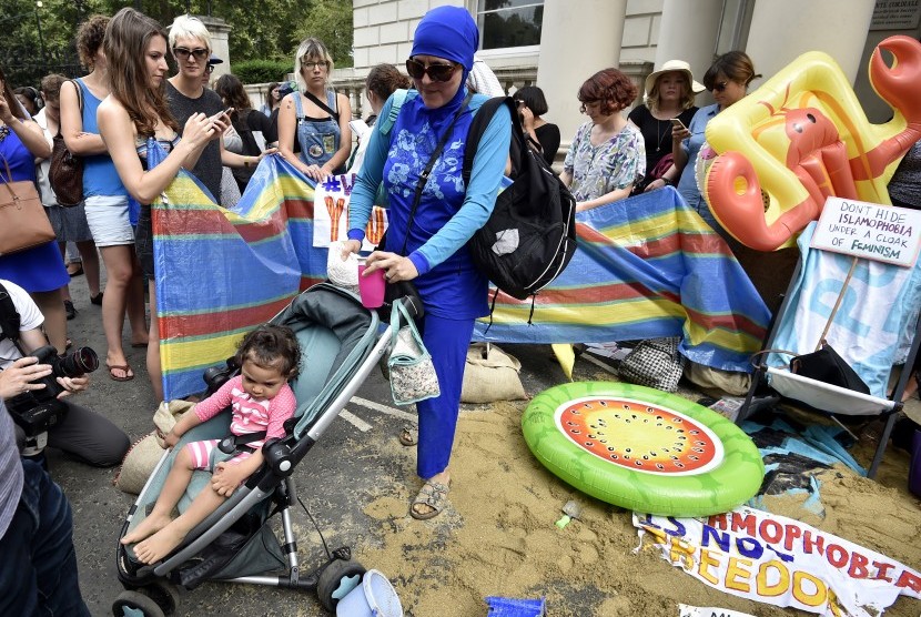 Wanita mengenakan burkini dalam rangka gerakan 'Wear What You Want Beach Party' di luar Kedubes Prancis di London. Aksi protes ini dilakukan untuk menunjukkan solidaritas terhadap Muslim Prancis.
