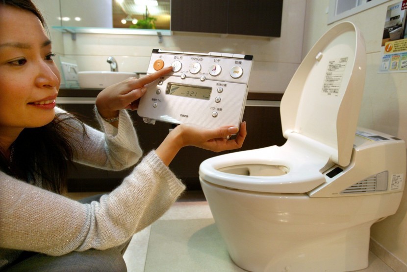 Wanita menunjukkan kecanggihan toilet di Jepang.