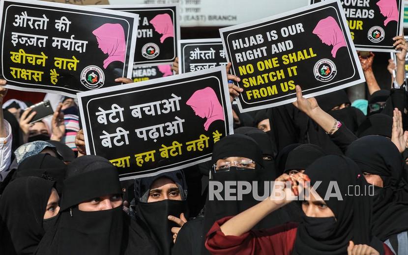  Wanita Muslim India memegang plakat dan meneriakkan slogan-slogan selama protes terhadap pembatasan jilbab di jalan Mira, di pinggiran Mumbai, India, 11 Februari 2022. Setahun Larangan Jilbab di Kampus Karnataka, Mahasiswa Muslim Masih Berjuang