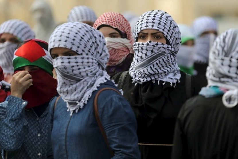 Wanita Palestina ambil posisi jelang bentrokan dengan aparat Israel di Ramallah, Sabtu (10/10). 
