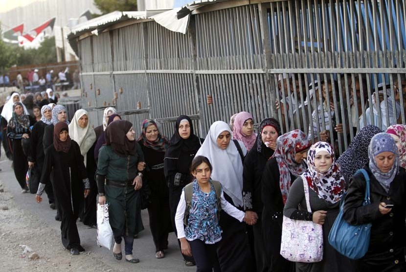 Wanita Palestina melewati sebuah pos pemeriksaan Israel di ruang terbuka sementara pria harus melalui jalan yang diberi pagar untuk menuju Masjid Al Aqsa di Yerusalem, Jumat (10/8).   (Nasser Shiyoukhi/AP)