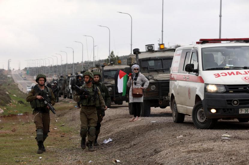  Wanita Palestina memegang bendera Palestina saat bentrokan dengan tentara Israel di desa Qusra dekat kota Nablus, Tepi Barat, (2/4/2020)..