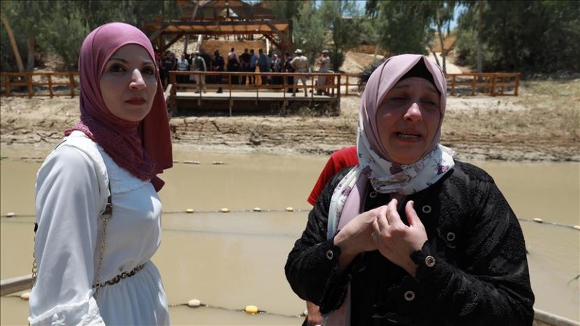 Wanita Palestina Sena Mohammed (kanan) bersatu kembali dengan keluarganya setelah 24 tahun di Sungai Jordan yang juga dikenal sebagai Nahr Al Syarieat di Jericho, Tepi Barat pada 17 Juni 2021. Sena bertemu kembali dengan anggota keluarganya, yang tinggal di Yordania. Sena mengklaim Israel tidak memberinya kartu identitas untuk bepergian ke luar negeri. 