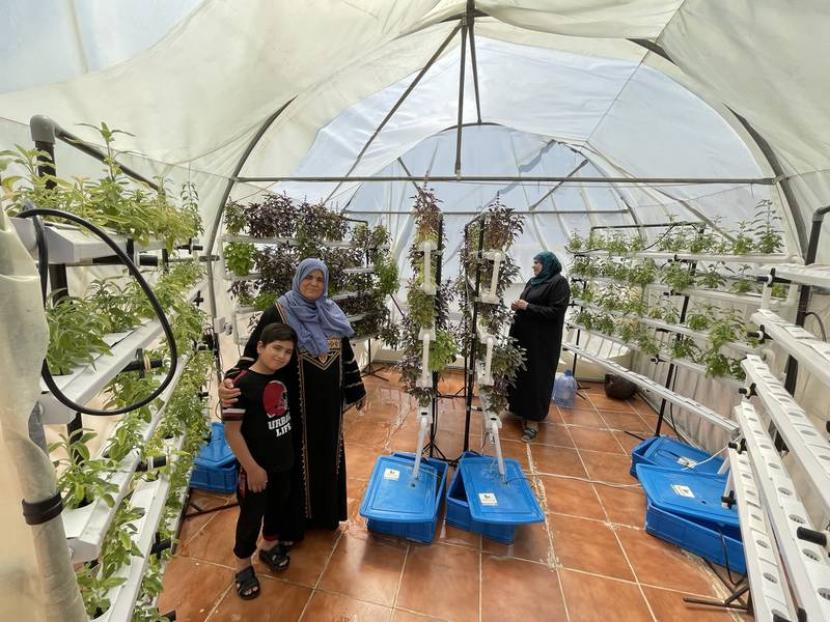 Wanita Suriah Hiyam Saeed bersama putranya. Ia menanam sayuran dan herba di atas atap gedung tempat tinggalnya di Amman, Yordania. Urban farming atau bertani di perkotaan membantu hidupnya. Urban Farming, Andalan Wanita Suriah untuk Bertahan Hidup di Yordania