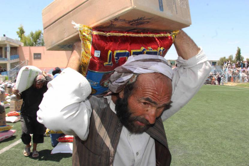Warga Afganistan membawa bantuan sembako 