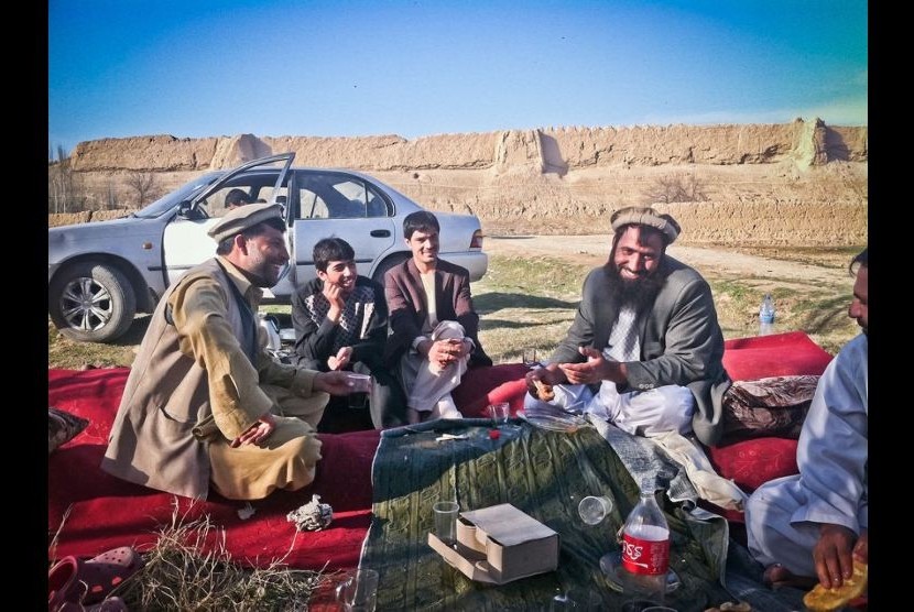Warga Afghan piknik di kota kuno, Balkh, menggelar karpet merah dengan menu lemak domba, roti tanpa ragi, gula dengan teh dan Coca-Cola