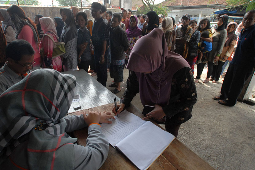 Warga antre mencairkan dana Program Simpanan Kesejahteraan Sosial (PSKS) di Kantor Pos, Tasikmalaya, Jawa Barat, Rabu (26/11). 