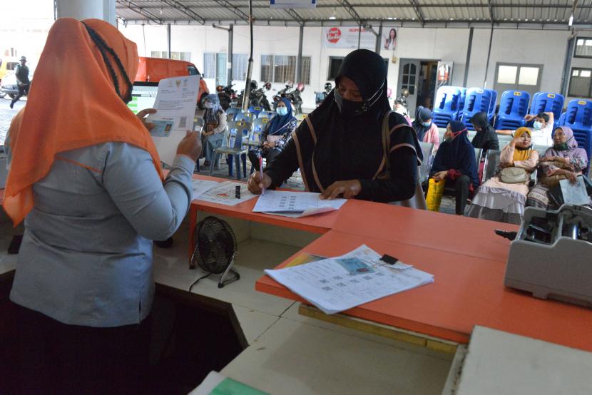 Warga antre mengambil Bantuan Sosial Tunai (BST) perdana tahun 2021 di kantor Pos Banda Aceh, Aceh, Senin (11/1/2021). PT POS Indonesia (Persero) tahun 2021 menyalurkan Bantuan Sosial Tunai (BST) sebesar 12 triliun untuk 10 juta Keluarga Penerima Manfaat (KPM) sebesar RP300.000 per KPM selama Januari hingga April 2021.