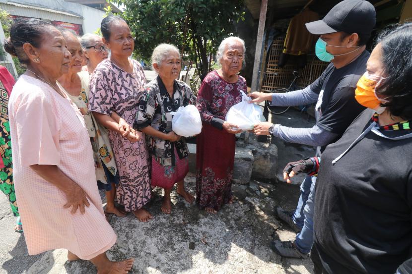 Warga antre untuk mendapatkan bantuan sembako di Kediri, Jawa Timur. Gubernur Jatim 2019-2024 Khofifah Indar Parawansa klaim kemiskinan ekstrem menurun.