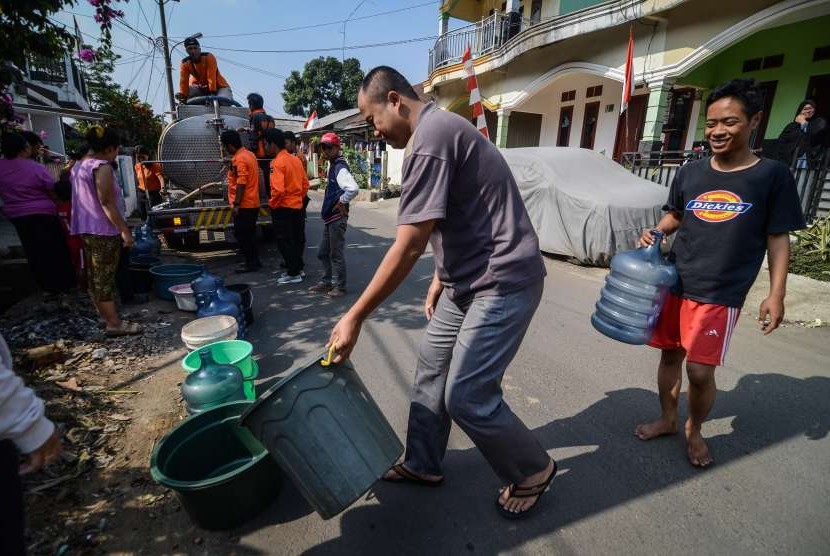 Warga antri untuk mendapatkan air bersih yang didistribusi oleh Petugas Badan Penanggulangan Bencana Daerah (BPBD) di Rancamaya, Bogor Selatan, Jawa Barat, Sabtu (18/8). 