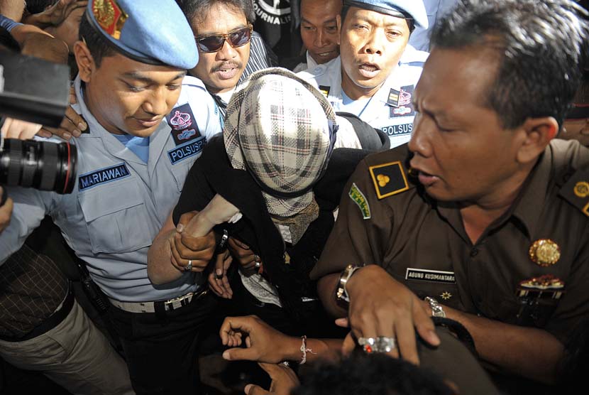  Warga Australia terpidana 20 tahun penjara dalam kasus penyelundupan mariyuana, Schapelle Leigh Corby (tengah) menutup wajahnya saat melengkapi administrasi bebas bersyarat di Kejaksaan Negeri Denpasar, Bali, Senin (10/2).   (Antara/Nyoman Budhiana)