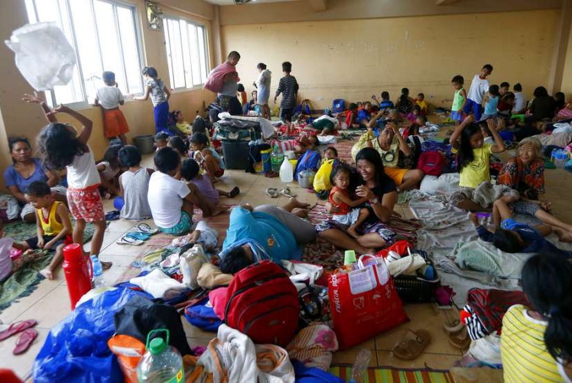 Warga Baseco berlindung dari terpaan Topan Mangkhut di Manila, Sabtu (15/9).