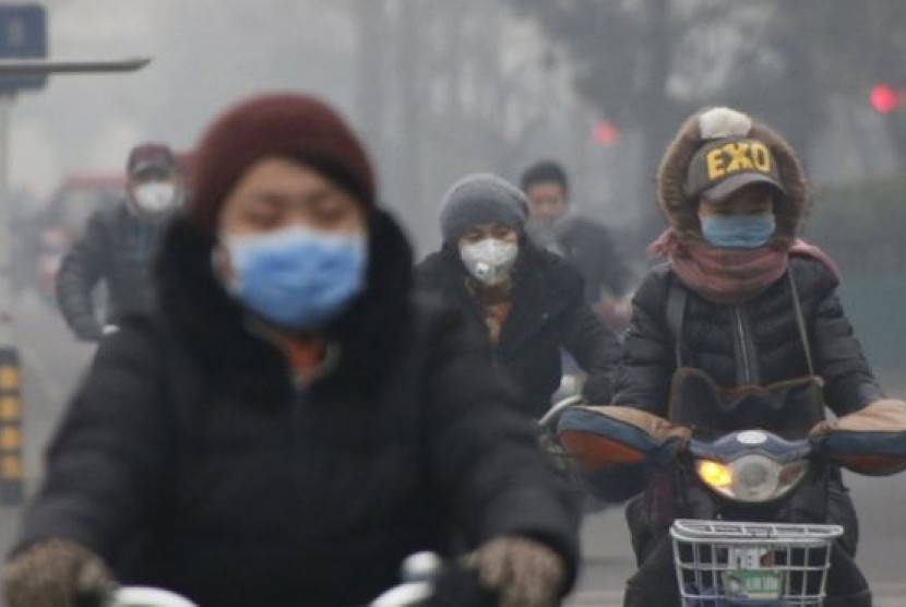 Warga Beijing beraktivitas di tengah asap dan kabut.
