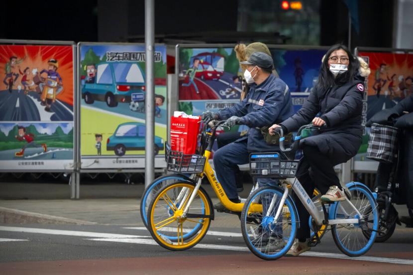 Warga Beijing, China, mengenakan masker sebagai upaya pencegahan Covid-19. Sejak Kamis (23/12), Pemerintah China melakukan lockdown terhadap Kota Xian yang berpenduduk 13 juta jiwa setelah kasus baru muncul dalam jumlah signifikan.