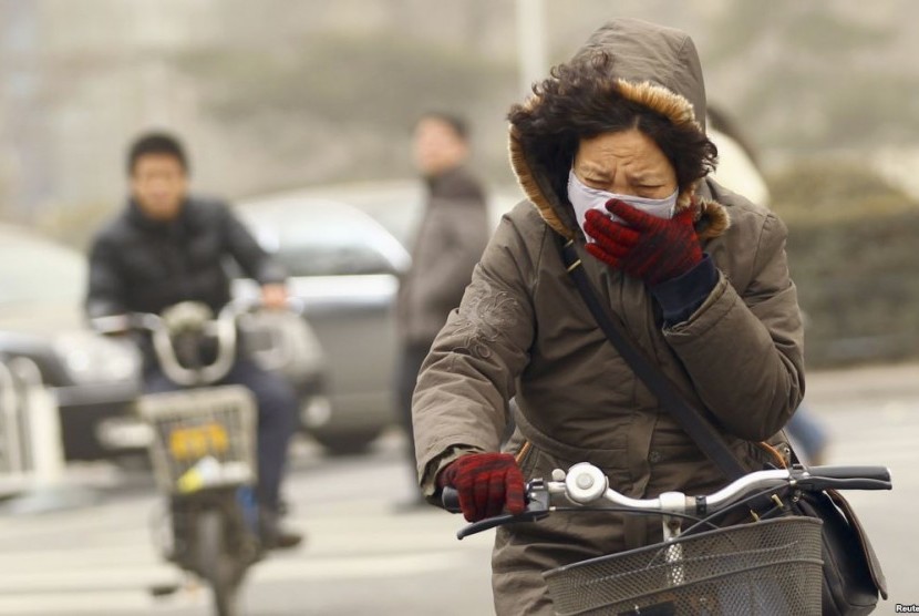 Warga Beijing menutupi wajah lantara kualitas udara yang memburuk.