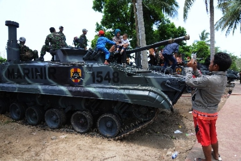 Warga berada di atas kendaraan panser Amfibi milik TNI AL di lokasi Sail Tomini 2015 di Pantai Kayubura, Pelawa Baru, Parigi Moutong, Sulawesi Tengah, Senin (14/9) 