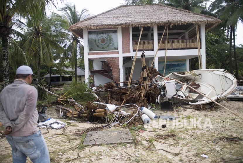 Warga berada di depan bangunan yang terdampak bencana Tsunami di Pantai Tanjung Lesung, Banten, Jawa Barat, Ahad (23/12/2018).