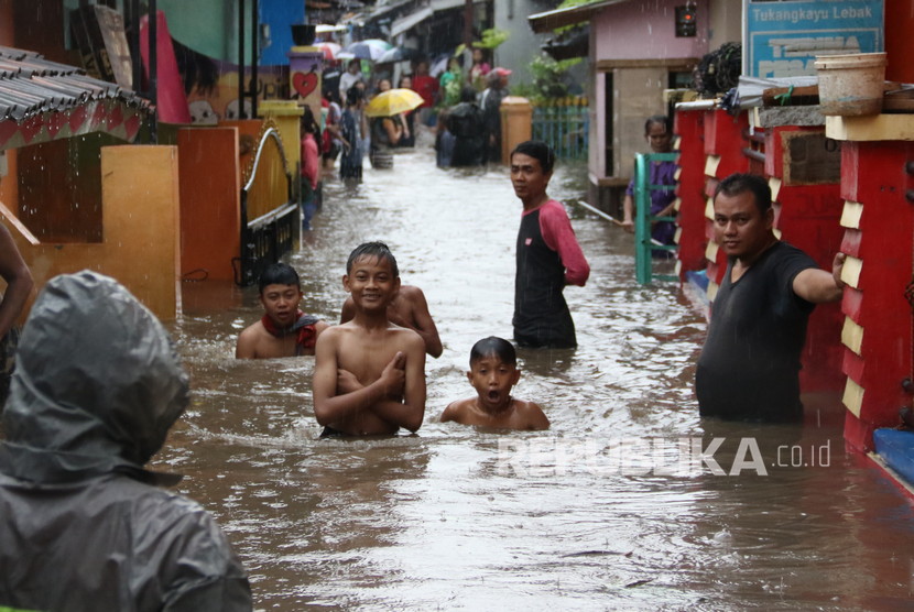Warga berada di lokasi banjir yang merendam rumahnya di Banyuwangi, Jawa Timur. Sebanyak 160 rumah warga terdampak.