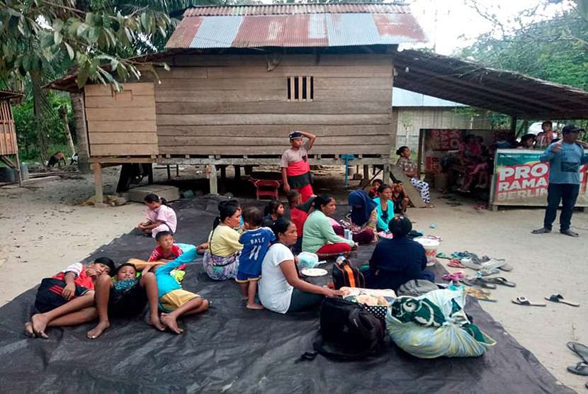 Warga berada di luar rumahnya pasca terjadi gempa bumi di kecamatan Sindue, Donggala, Sulawesi Tengah, Jumat (28/9).