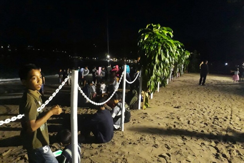 Warga berada di Pantai Senggigi, Lombok Barat, NTB, merayakan malam pergantian tahun, Ahad (31/12).