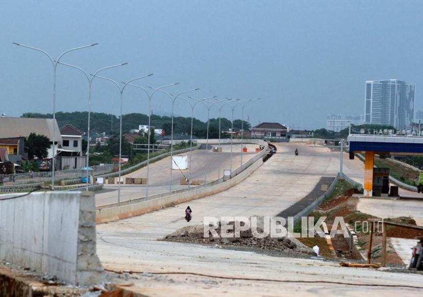 Warga berada di proyek jalan Tol Kunciran-Cengkareng di Cipondoh, Tangerang, Banten, Senin (16/11/2020). Hingga 14 Februari 2021 pengerjaan konstruksi proyek jalan tol sepanjang 14,19 Km ini telah mencapai 93,06 persen.