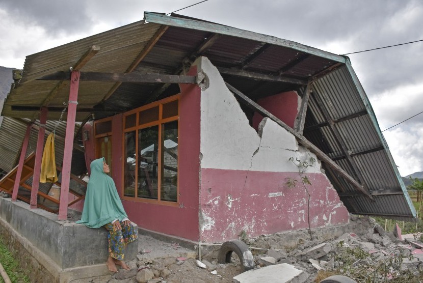 Warga berada di rumahnya yang rubuh akibat gempa di Desa Sembalun Bumbung, Kecamatan Sembalun, Selong, Lombok Timur, NTB, Minggu (29/7). Gempa bumi 6,4 Skala Richter (SR) mengguncang wilayah Lombok, Nusa Tenggara Barat, Ahad (29/7).