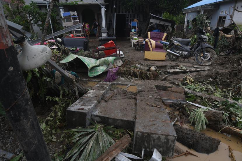 Warga berada di sekitar rumah yang rusak akibat diterjang banjir bandang di Desa Torue, Kabupaten Parigi Moutong, Sulawesi Tengah, Jumat (29/7/2022). Banjir bandang yang terjadi pada Kamis (28/7/2022) malam tersebut mengakibatkan tiga orang meninggal dunia, empat orang dinyatakan hilang dan masih dalam pencarian, serta puluhan rumah warga rusak. 