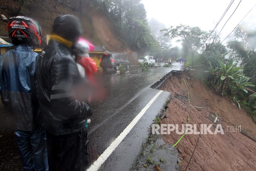 Warga berada di sekitar tempat terjadinya longsor di jalur utama Puncak Bogor, Jawa Barat, Senin (5/2). 