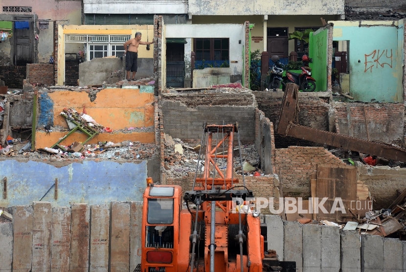 Warga berada dirumah yang sudah dibongkar di Bukit Duri, Jakarta Selatan, Rabu (14/9).