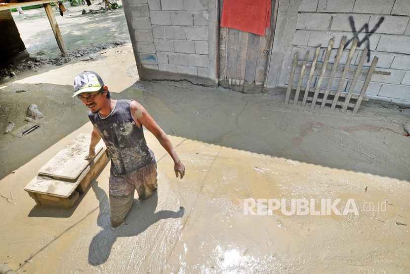 Warga berada disekitar rumah yang rusak dan terendam lumpur akibat diterjang banjir bandang di Desa Poi, Kabupaten Sigi, Sulawesi Tengah, Ahad (8/12/2019).
