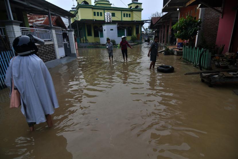 Warga berada disekitar rumahnya yang terendam banjir di Kampung Baru di Palu, Sulawesi Tengah, Sabtu (3/7/2021). Banjir yang merendam sejumlah rumah warga itu diakibatkan hujan lebat yang melanda Kota Palu serta wilayah hulu Sungai di Kabupaten Sigi hingga Sungai Palu meluap.