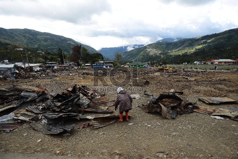   Warga beraktifitas di lokasi terbakarnya kios dan Mushollla di Tolikara, Papua, Kamis (23/7). 