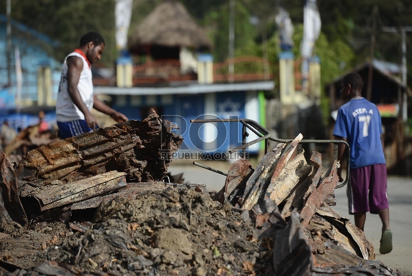  Warga beraktivitas di lokasi terbakarnya kios dan mushalla di Tolikara, Papua, Kamis (23/7). 