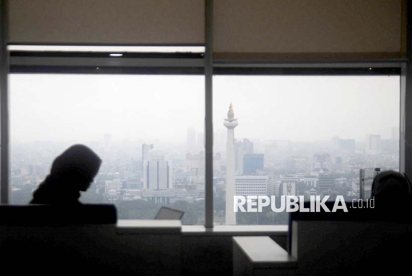 Warga beraktivitas dengan latar belakang gedung bertingkat yang terlihat samar karena polusi udara di Jakarta, Selasa (6/6/2023). Kualitas udara dalam ruangan yang buruk bisa berdampak pada kesehatan.