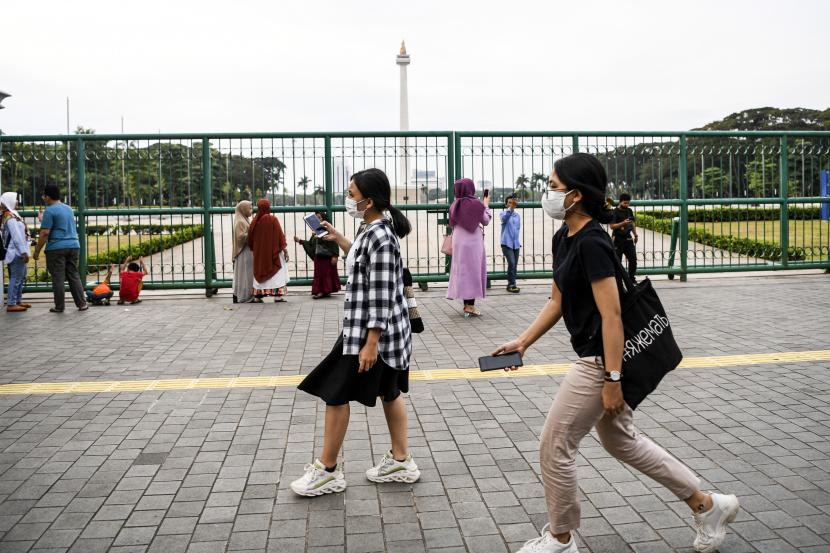 Warga beraktivitas dengan latar belakang Monumen Nasional (Monas), Jakarta, Kamis (16/6/2022). WHO: Miliaran Orang Hidup dengan Masalah Kesehatan Mental
