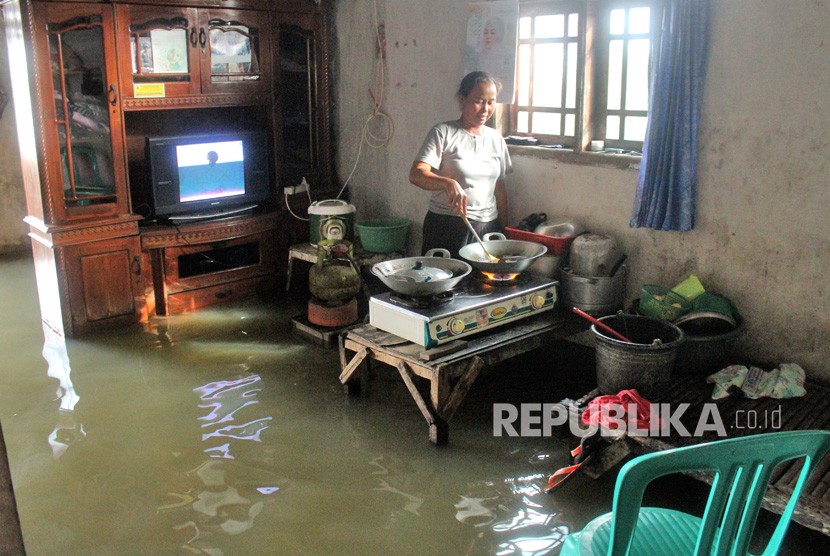 Warga beraktivitas di dalam rumahnya yang terendam banjir di Babelan, Kabupaten Bekasi, Jawa Barat, Selasa (6/2).