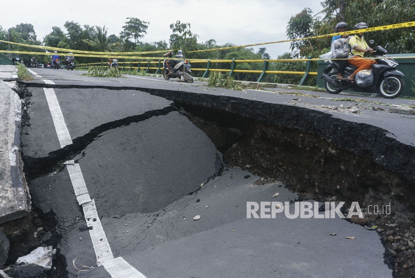 Warga beraktivitas di dekat jembatan yang ambles di Imogiri, Bantul, DI Yogyakarta, Kamis (30/11). 