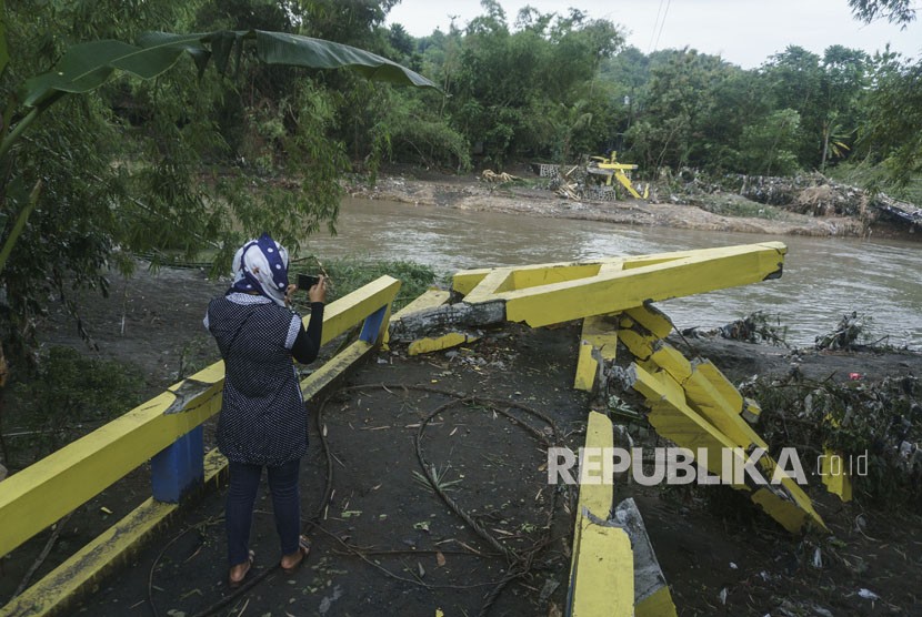 Warga beraktivitas di dekat jembatan yang rusak di Imogiri, Bantul, DI Yogyakarta, Kamis (30/11).