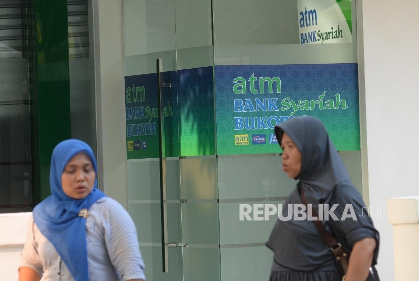 Warga beraktivitas di depan mesin Anjungan Tunai Mandiri (ATM) Bank Syariah Bukopin, Jakarta, Ahad (10/9).