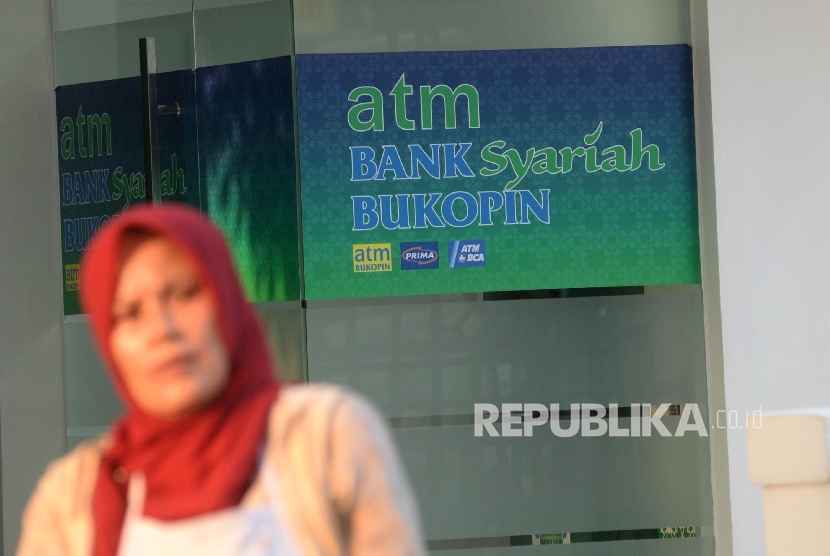  Warga beraktivitas di depan mesin Anjungan Tunai Mandiri (ATM) Bank Syariah Bukopin, Jakarta, Ahad (10/9). 