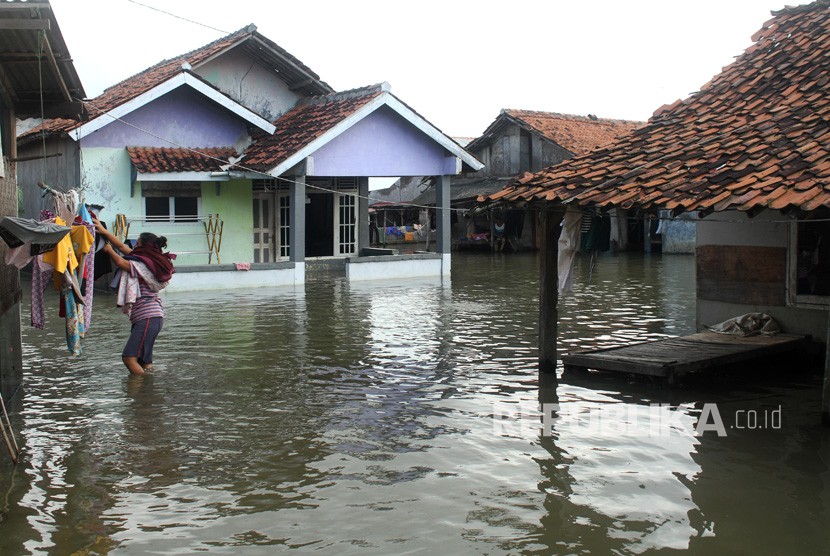 Warga beraktivitas di kawasan permukiman penduduk yang terendam banjir, di Babelan, Kabupaten Bekasi, Jawa Barat, Selasa (6/2).