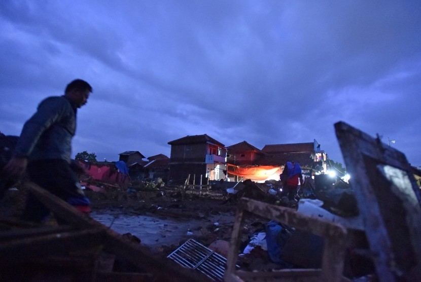 Warga beraktivitas di lokasi bangunan yang rusak akibat banjir bandang aliran Sungai Cimanuk di Kampung Cimacan, Tarogong, Kabupaten Garut, Jawa Barat, Jumat (23/9). 