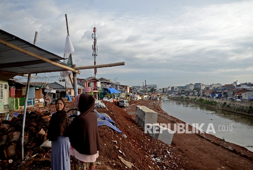 Warga beraktivitas di sekitar area proyek normalisasi Kali Cliwung di Kelurahan Bukit Duri, Jakarta, Senin (9/1)