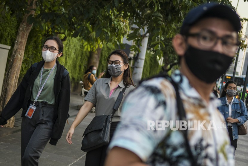 Warga beraktivitas menggunakan masker di kawasan Bunderan Hotel Indonesia, Jakarta, Senin (2/3/2020). 