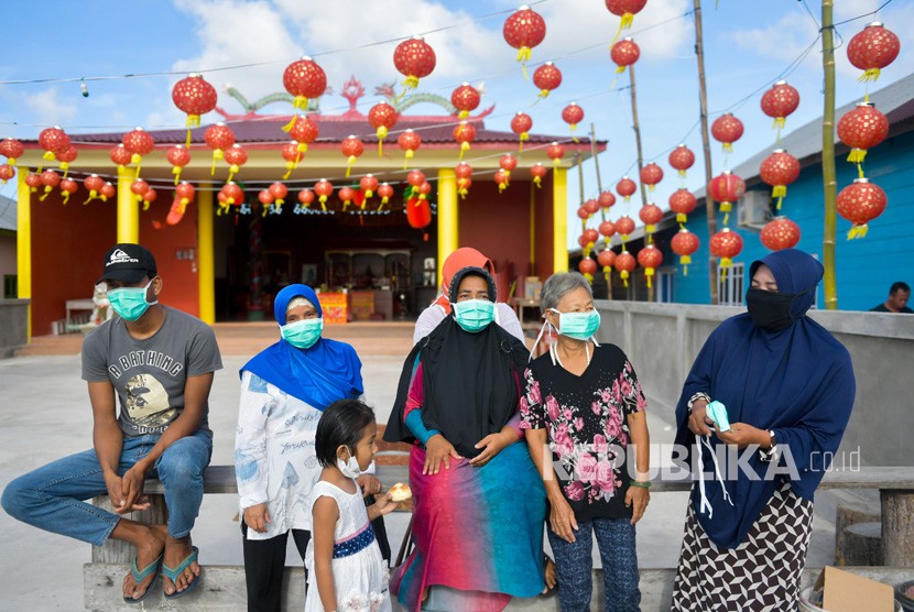 Warga beraktivitas menggunakan masker di Kota Tua Penagi, Natuna, Kepulauan Riau, Kamis (6/2/2020). 