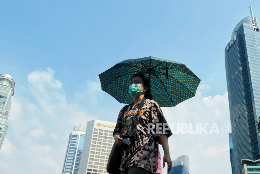 Warga beraktivitas saat cuaca terik di kawasan Bundaran Hotel Indonesia, Jakarta, Senin (24/4/2023).