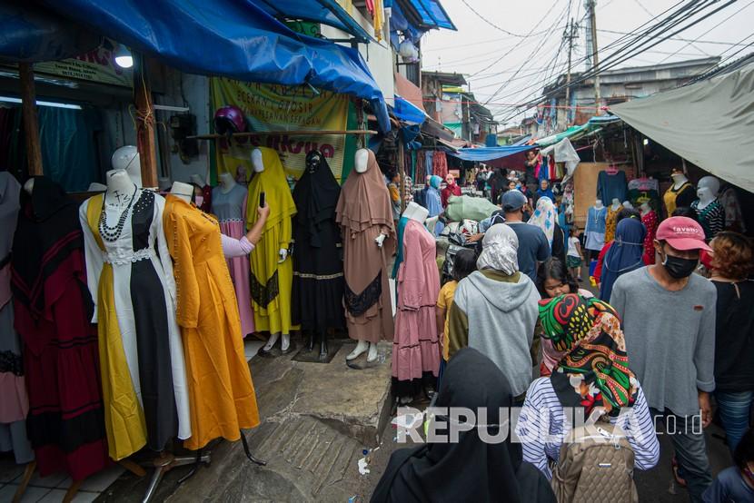 Warga berbelanja pakaian yang dijual pedagang kaki lima di Jalan Jati Baru II, Tanah Abang, Jakarta, Senin (18/5/2020). Meski kawasan niaga Pasar Tanah Abang telah tutup selama masa Pembatasan Sosial Berskala Besar (PSBB), namun sebagian oknum pedagang tetap menggelar lapaknya di sejumlah titik seperti di atas trotoar dan di gang perkampungan setempat. 