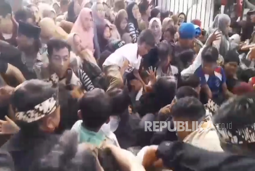 Warga berdesak-desakan ingin masuk ke pendopo Pemkab Garut pada acara pesta rakyat pernikahan Maula Akbar Mulyadi anak Gubernur Jawa Barat Dedi Mulyadi dengan Wakil Bupati Garut Putri Karlina, Jumat (18/7/2025). Tiga orang meninggal dunia akibat peristiwa desak-desakan tersebut, dua orang warga dan satu orang polisi.