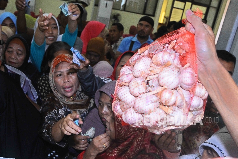 Warga berdesak desakan membeli bawang putih saat pembukaan Toko Tani Indonesia (TTI) di kawasan Pasar Minggu, Jakarta, Rabu (15/6). (Republika/ Agung Supriyanto)